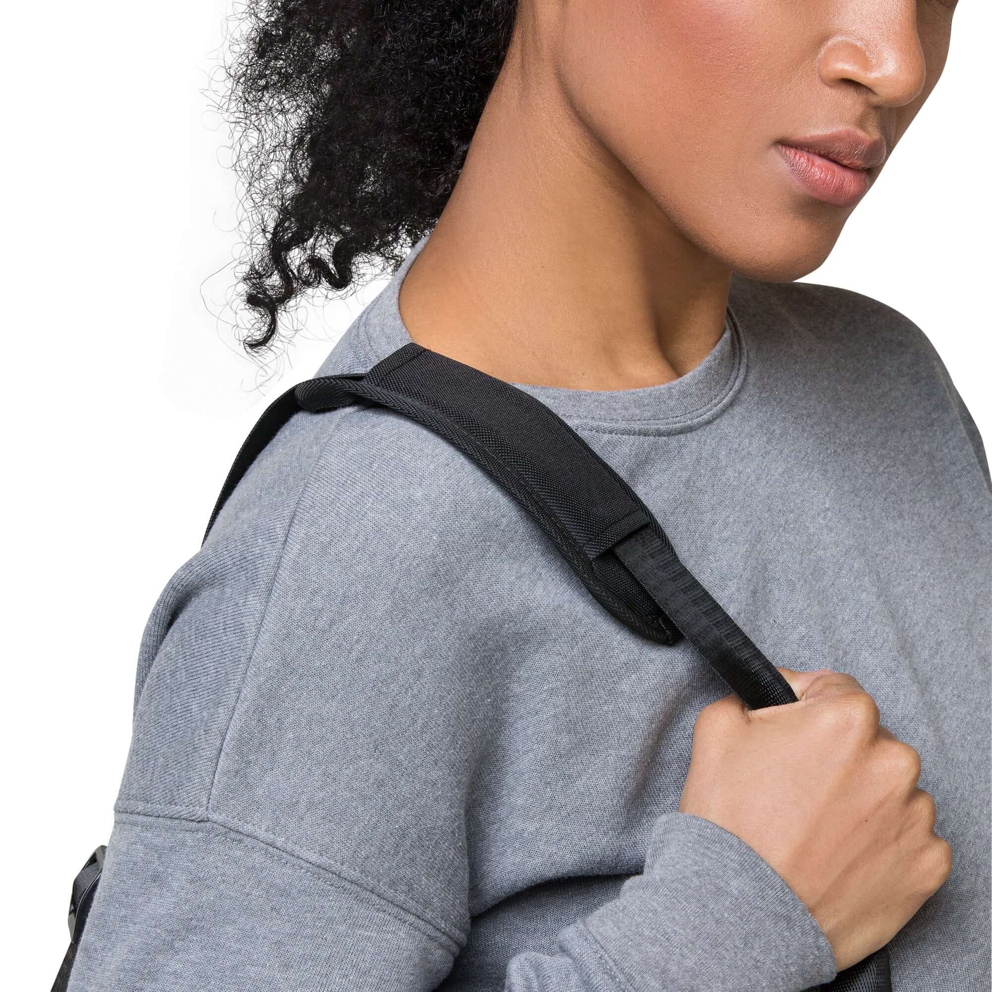 Woman holding Art Deco Filigreee Duffle bag for men strap stylishly while wearing a gray sweatshirt.