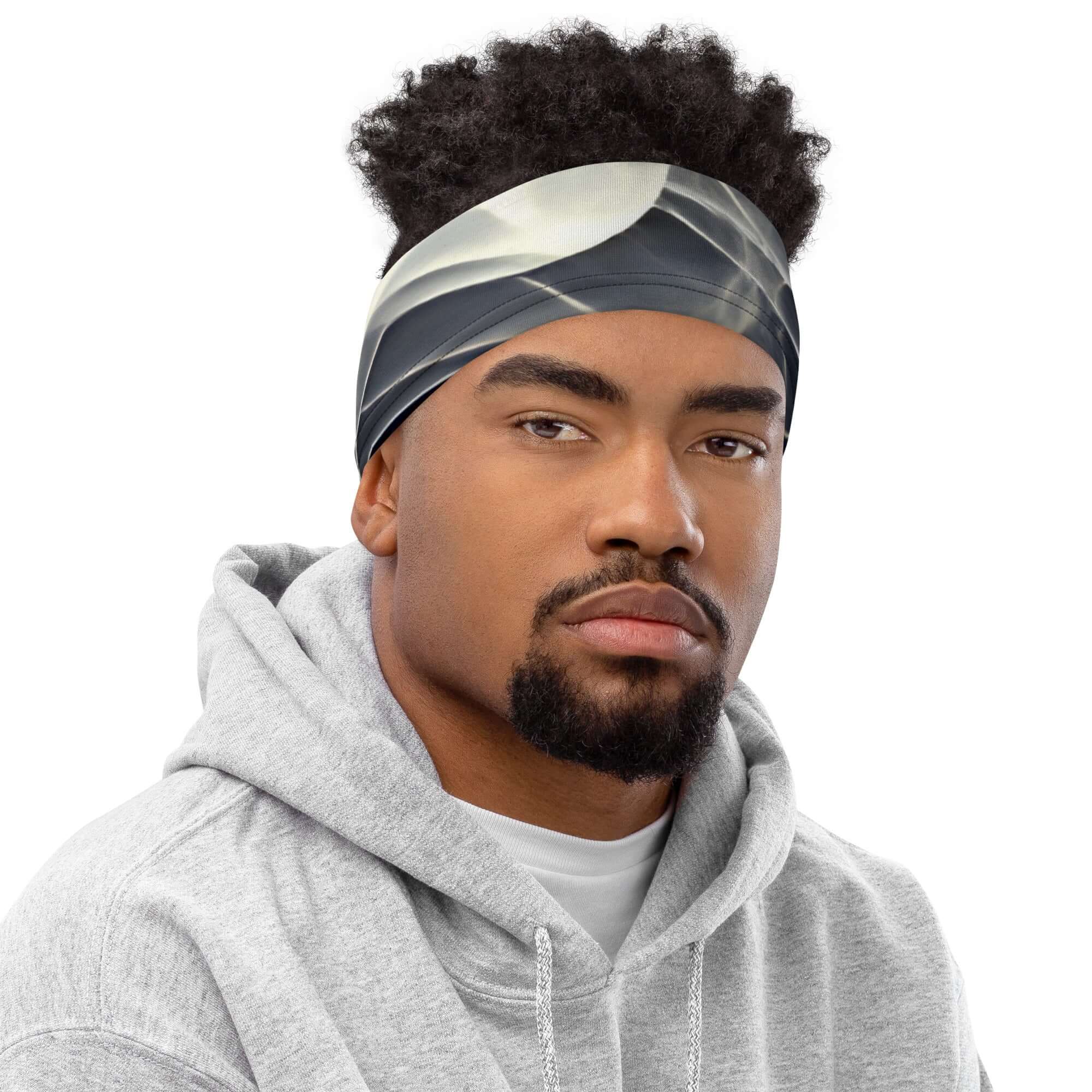 Smoke pattern gaiter worn as a headband on a man in a gray hoodie.