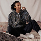art deco filigree zip hoodie worn by a model sitting comfortably on a rug, showcasing the intricate pattern.