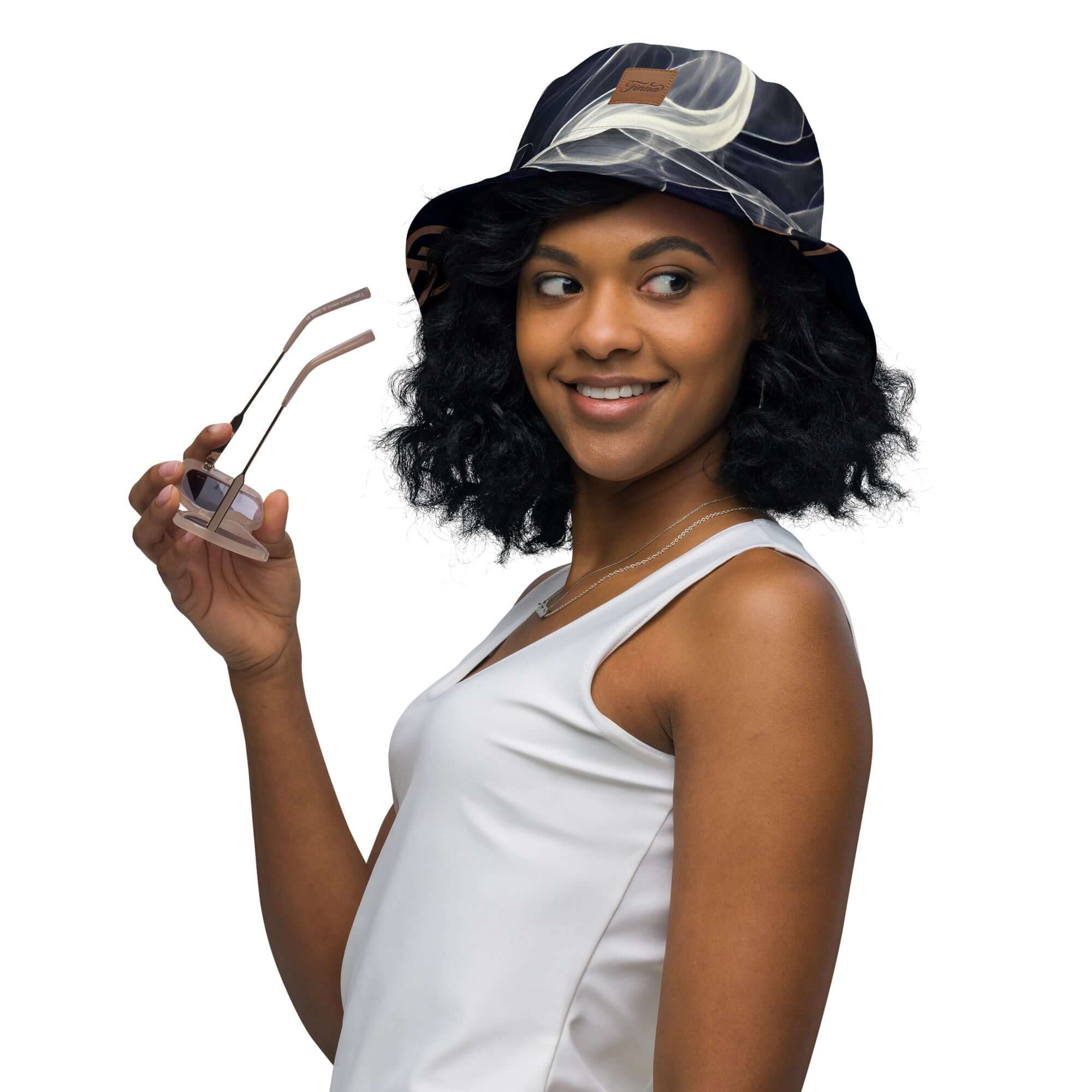 Reversible bucket hat streetwear worn by a woman holding sunglasses, showcasing a stylish streetwear look.