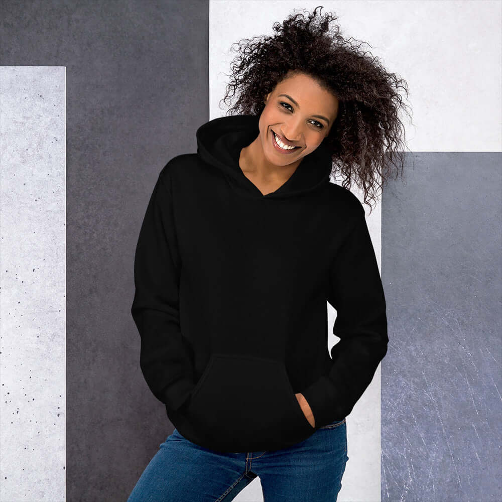 Lynxdonk Unisex Hoodie Cozy and Stylish Essential in black, modeled by a smiling woman against a geometric background.