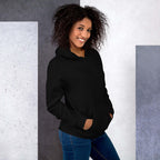 Lynxdonk Unisex Hoodie Cozy and Stylish Essential worn by woman with curly hair, showcasing a black hoodie in a modern setting.
