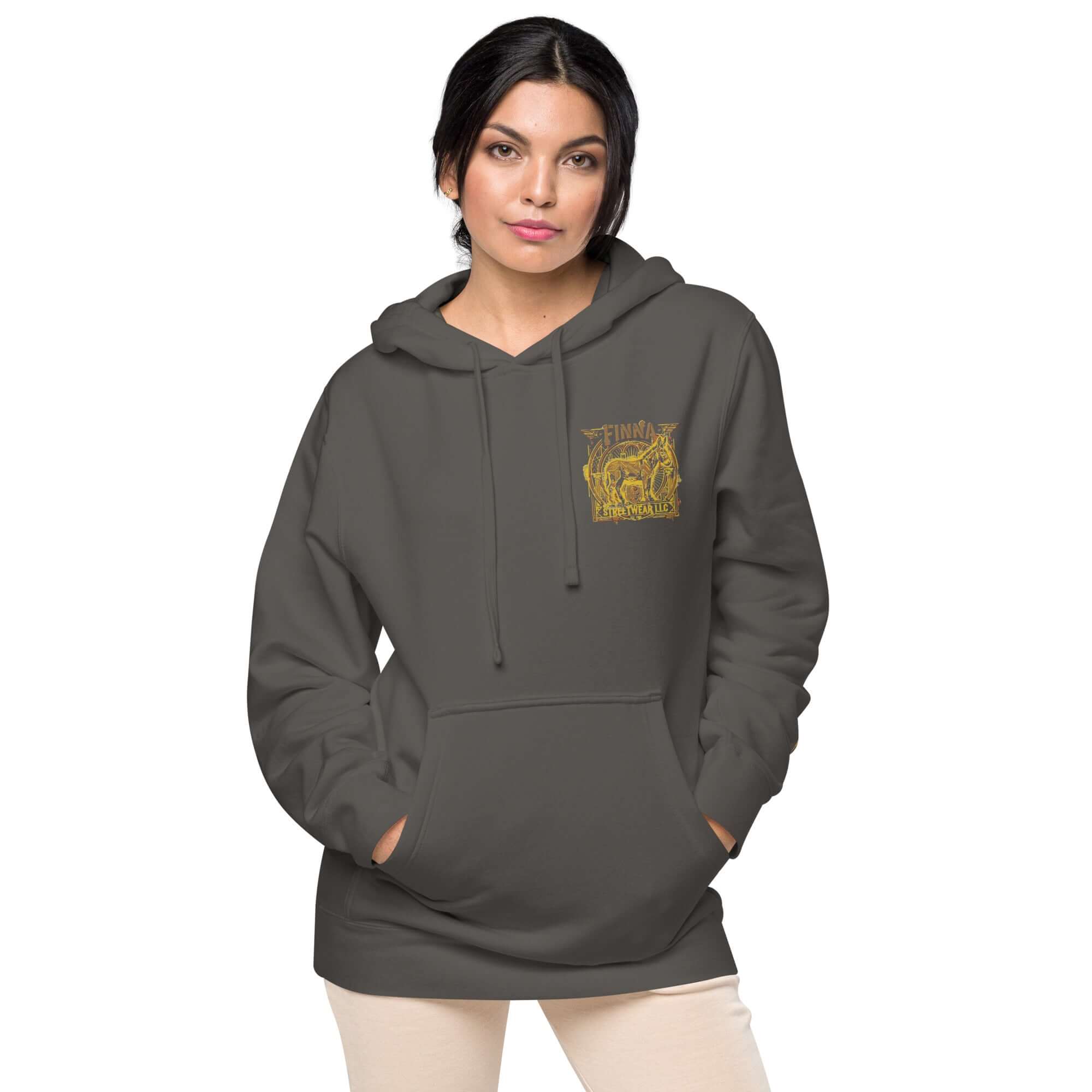LynxDonkey Unisex pigment-dyed hoodie in dark gray worn by a woman with a gold graphic design.